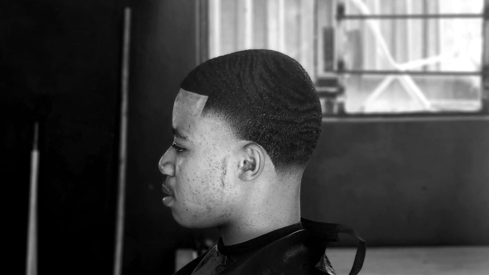Cliente de perfil con un fade recién hecho en la barbería